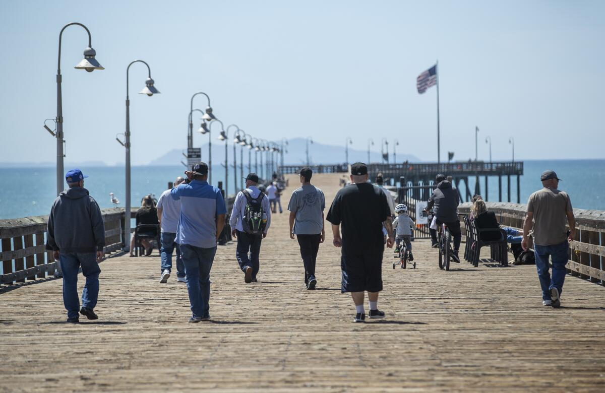 People visit the Ventura Pier on Monday.
