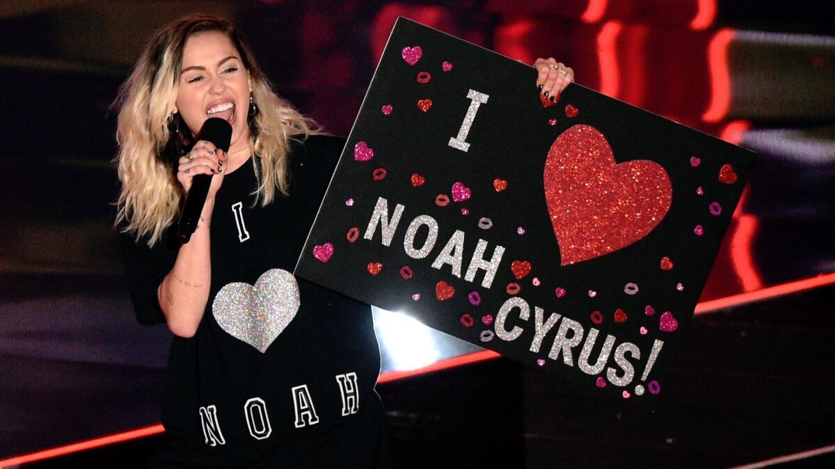 Miley Cyrus introduces a performance by Noah Cyrus and Labrinth at the iHeartRadio Music Awards.
