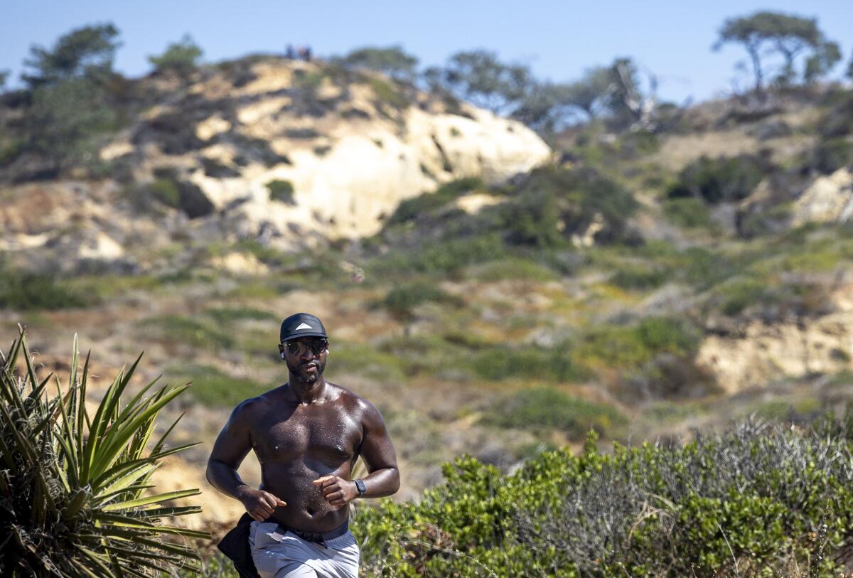 Caliph Assagai, of San Diego, jogs along the Beach Trail at Torrey Pines State Natural Reserve on Thursday.