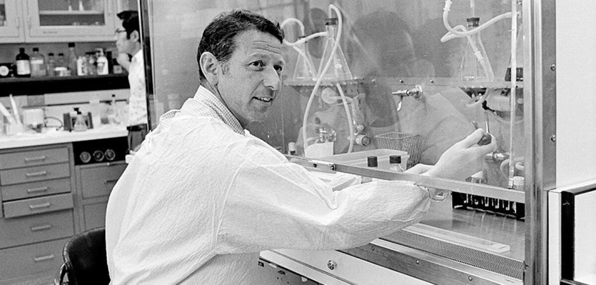 Paul Berg in a lab in a black-and-white photo.