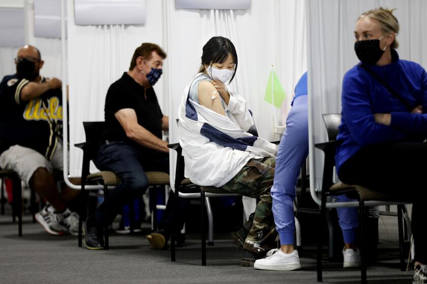 SANTA ANA-CA-APRIL 22, 2021: Huong Vu, 20, of Santa Ana, receives a moderna vaccine at a new mass vaccination site in Orange County-the Providence Vaccine Clinic at Edwards Lifescience in Santa Ana on Thursday, April 22, 2021. (Christina House / Los Angeles Times)