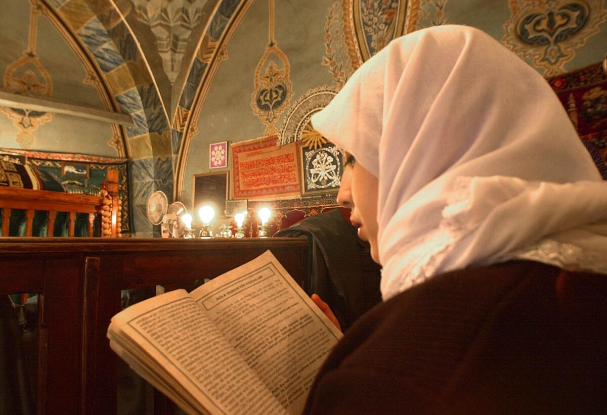 A Turkish girl reads the Koran at the Hadji Bayram Mosque in Ankara.
