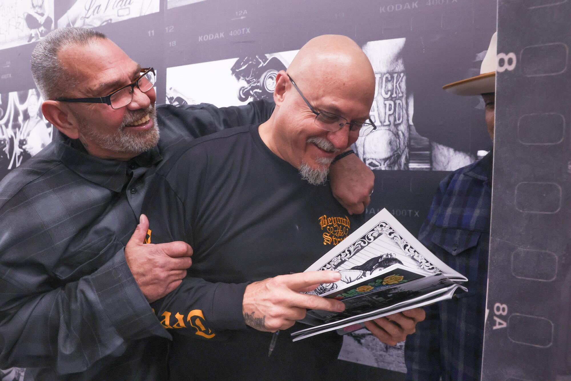 Estevan Oriol is embraced by OG Lepke, who he took many photos of, during the opening at Beyond The Streets Gallery.