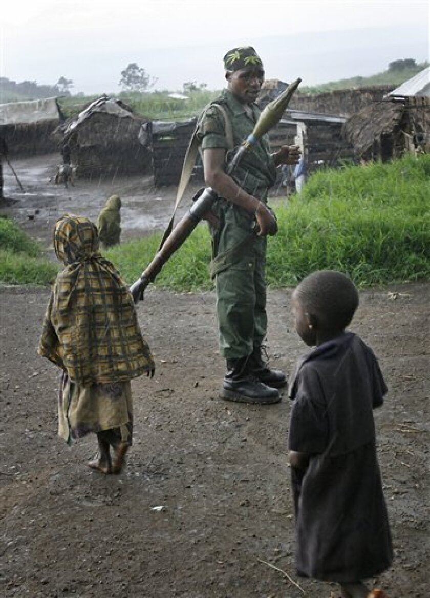 Rebels loyal to Laurent Nkunda's movement are seen in Tongo, some 100 kilometers (62 miles) north of Goma, in eastern Congo, Sunday, Nov. 2, 2008. Thousands of war-weary refugees returned to the the road taking advantage of a rebel-called cease-fire to try to reach home beyond the front lines of this week's battles in eastern Congo. (AP Photo/Jerome Delay)