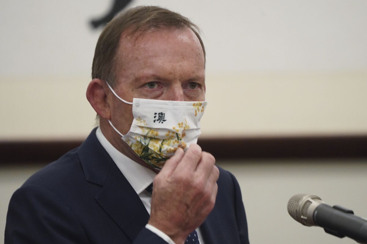 FILE - In this Oct. 7, 2021, file photo, former Australian Prime Minister Tony Abbott wears a mask with the Chinese character for "Australia" during a meeting with Taiwanese President Tsai Ing-wen at the Presidential Office in Taipei, Taiwan. Abbott accused China of being a bully and expressed enthusiastic support for Taiwan while visiting the democratically ruled island. “Nothing is more pressing right now than solidarity with Taiwan," Abbott told a conference Friday, Oct. 8, 2021. (Pool Photo via AP Photo, File)