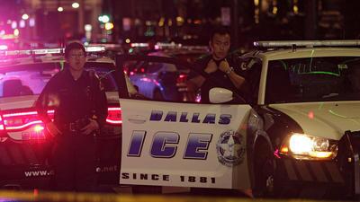 Dallas police officers gather downtown after the deadly shooting.