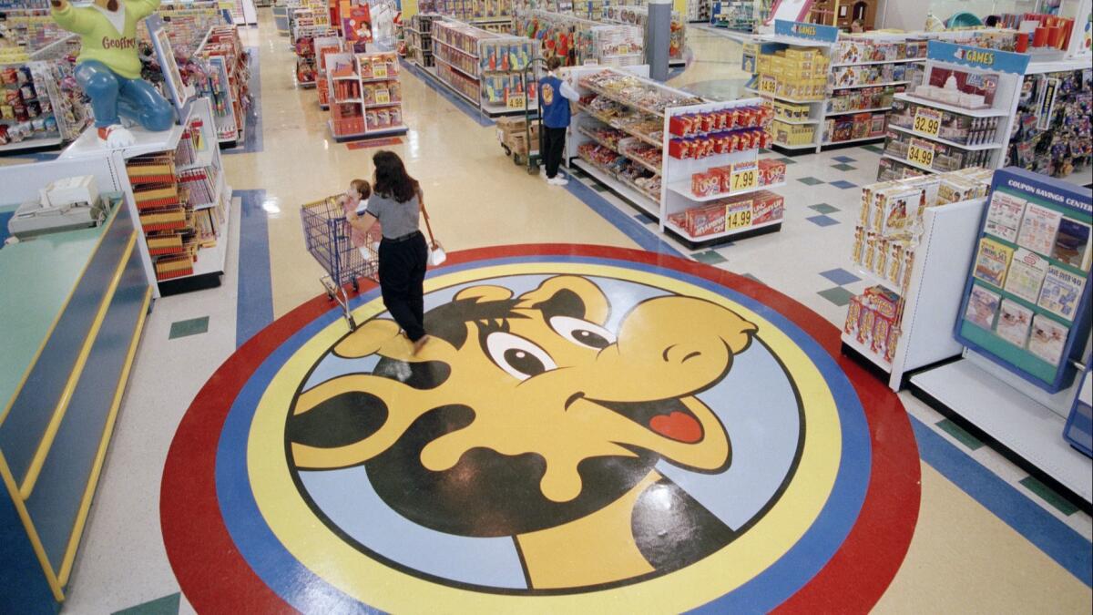 A woman pushes a cart over a graphic of Toys R Us mascot Geoffrey the giraffe at an old Toys R Us store in Raritan, N.J. Richard Barry, chief executive of a new company called Tru Kids, is exploring how best to bring back the brand.