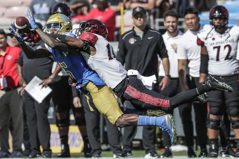 UCLA receiver Jaylen Erwin is challenged by San Diego State cornerback Luq Barcoo.