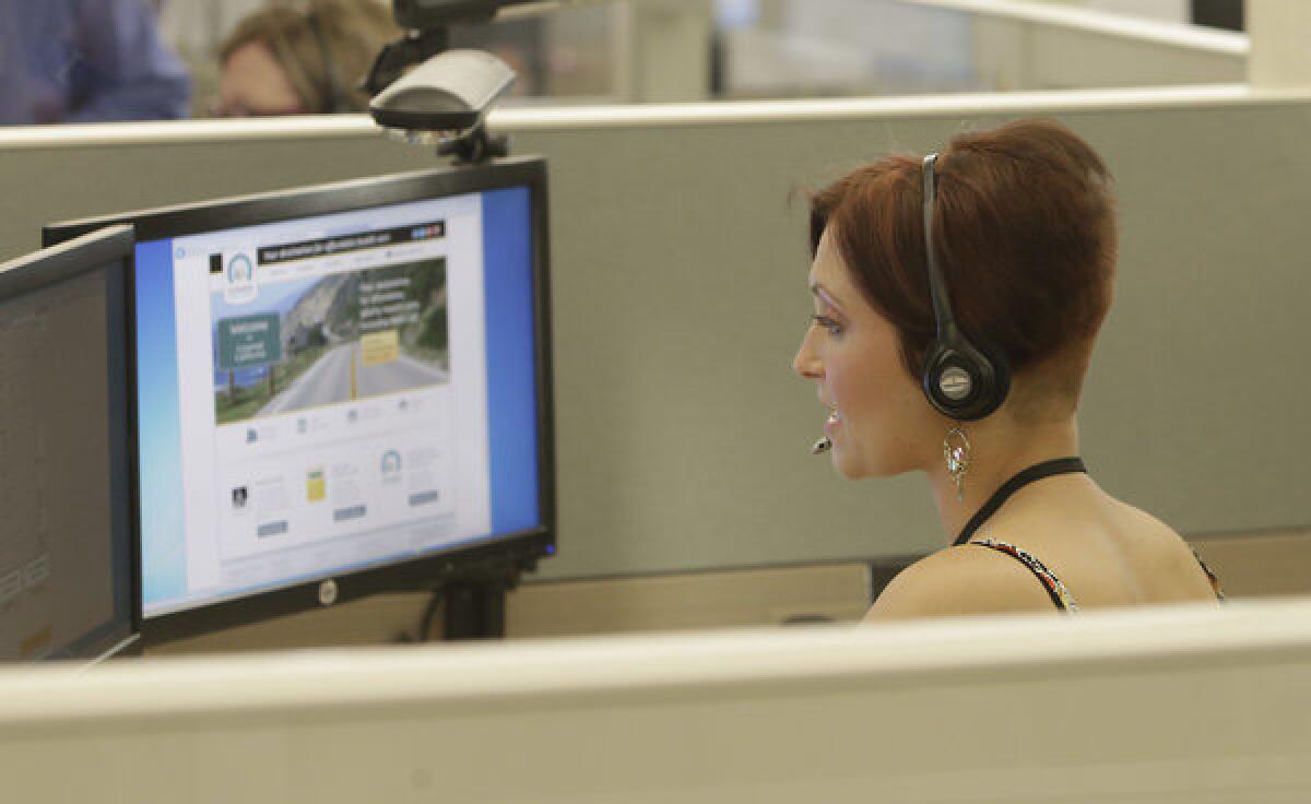 Gina Macaluso, an employee of Covered California, the state's new health insurance exchange, talks to a prospective customer at the call center in Rancho Cordova, Calif., Tuesday.