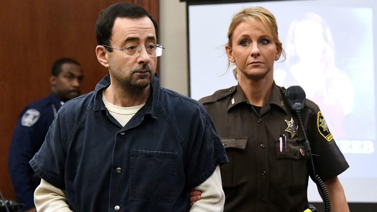 Larry Nassar is escorted into the courtroom Friday. USA Gymnastics announced Monday that three board members have tendered their resignations.