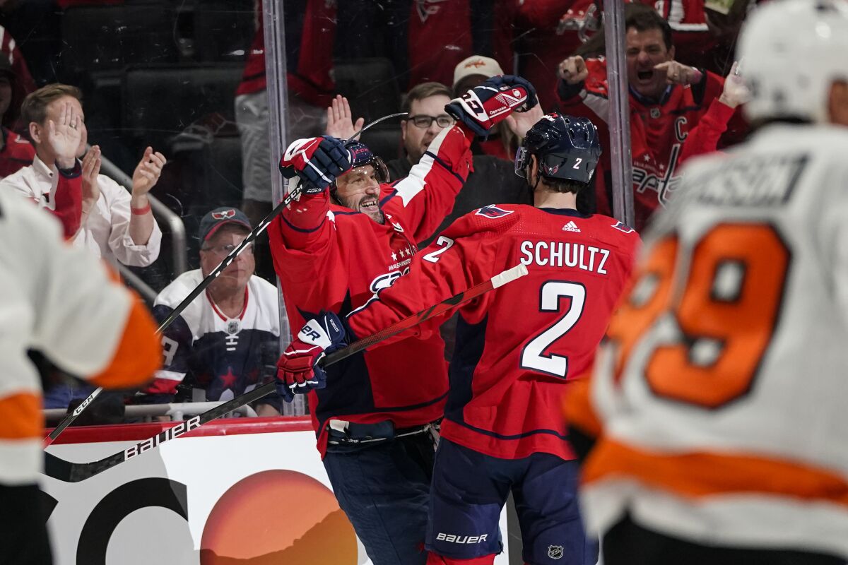 Washington Capitals left wing Alex Ovechkin, left, and defenseman Justin Schultz celebrate Ovechkin's goal during the first period of the team's NHL hockey game against the Philadelphia Flyers, Tuesday, April 12, 2022, in Washington. (AP Photo/Alex Brandon)