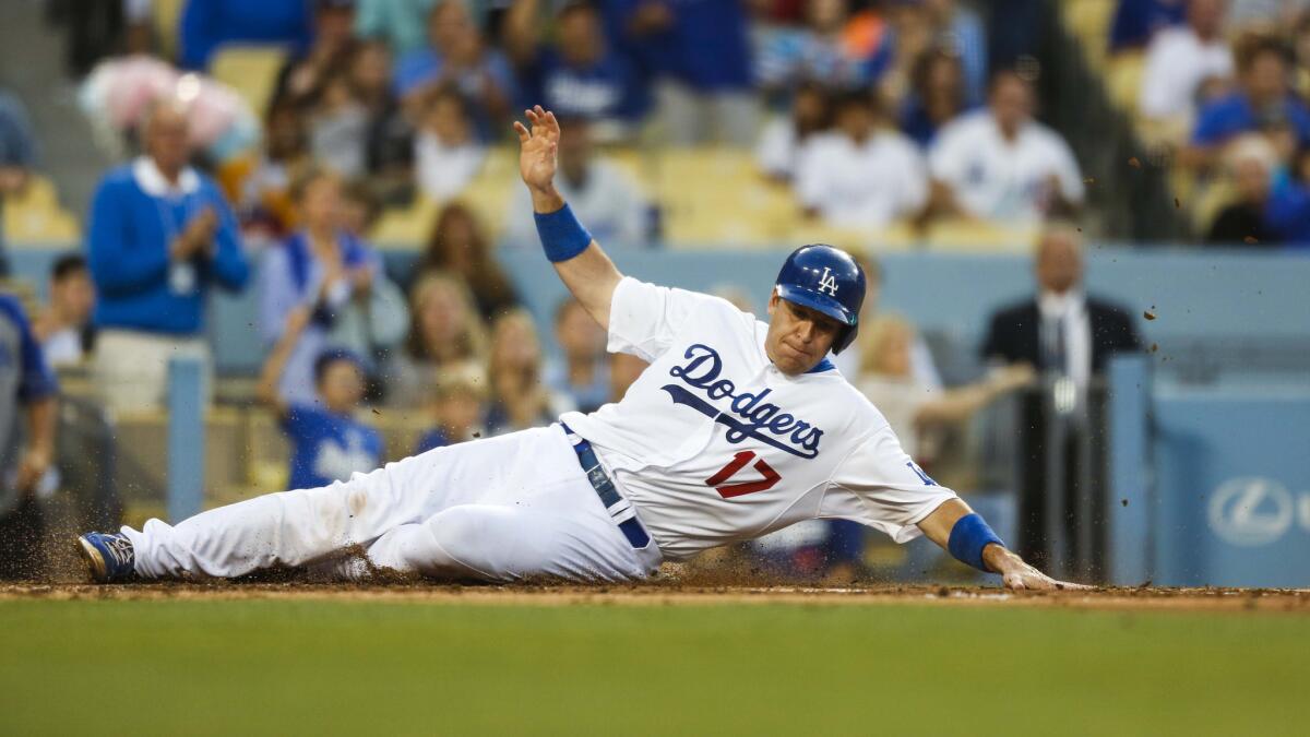 Dodgers catcher A.J. Ellis slides into home plate to score during a game against the St. Louis Cardinals in June.