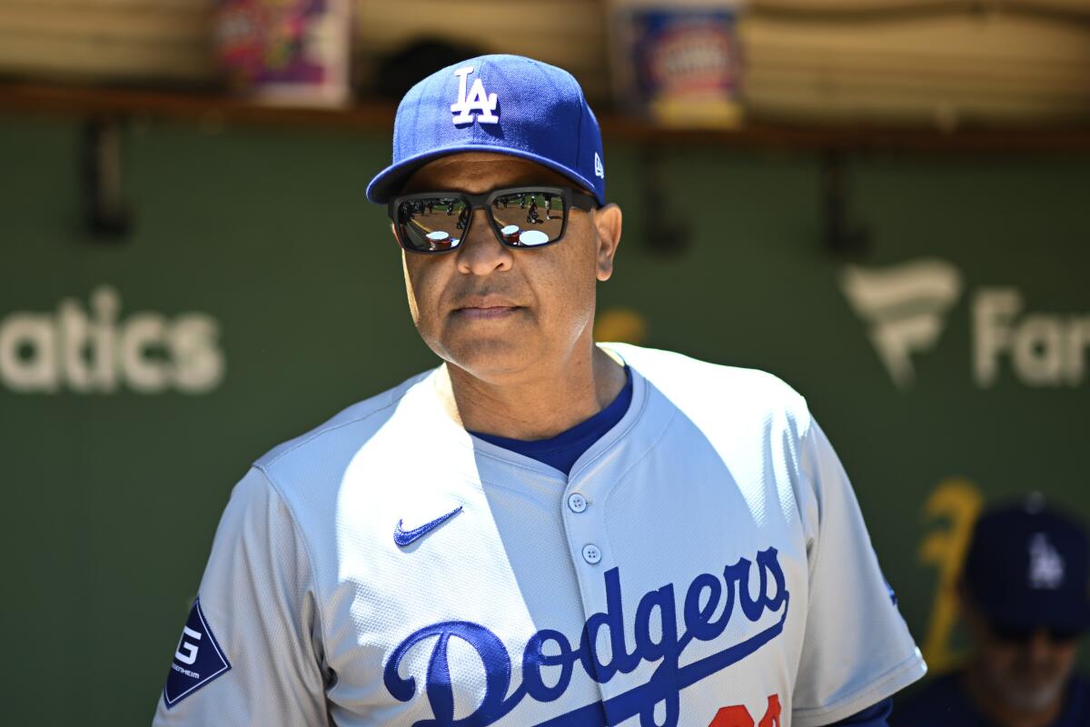 Dodgers manager Dave Roberts stands in the dugout before Sunday's game against the Athletics in Oakland