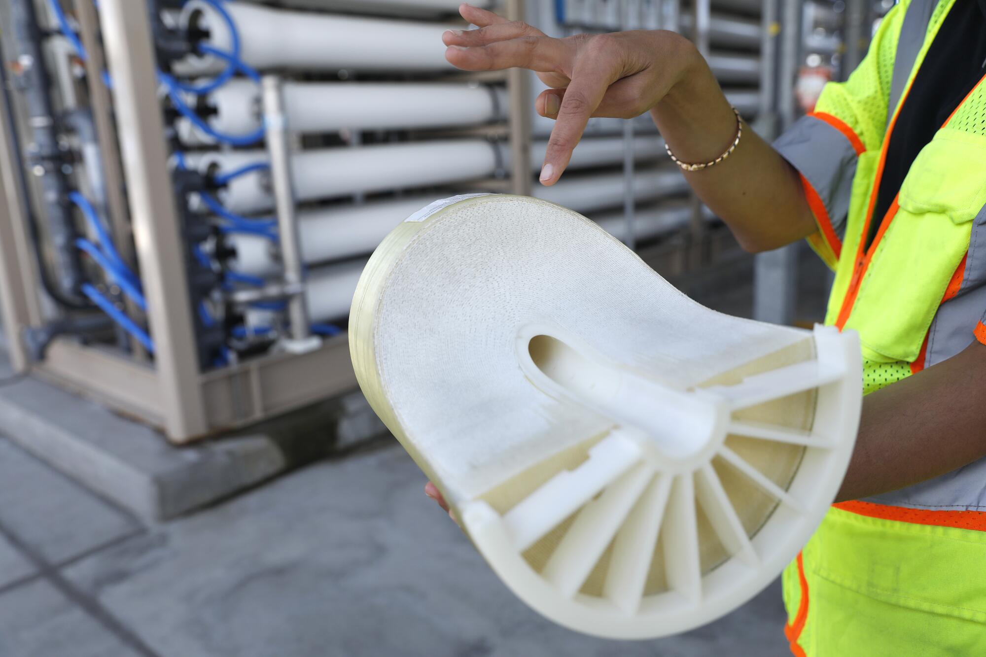 Rupam Soni shows a cutaway of a piece of a reverse-osmosis water treatment system. 