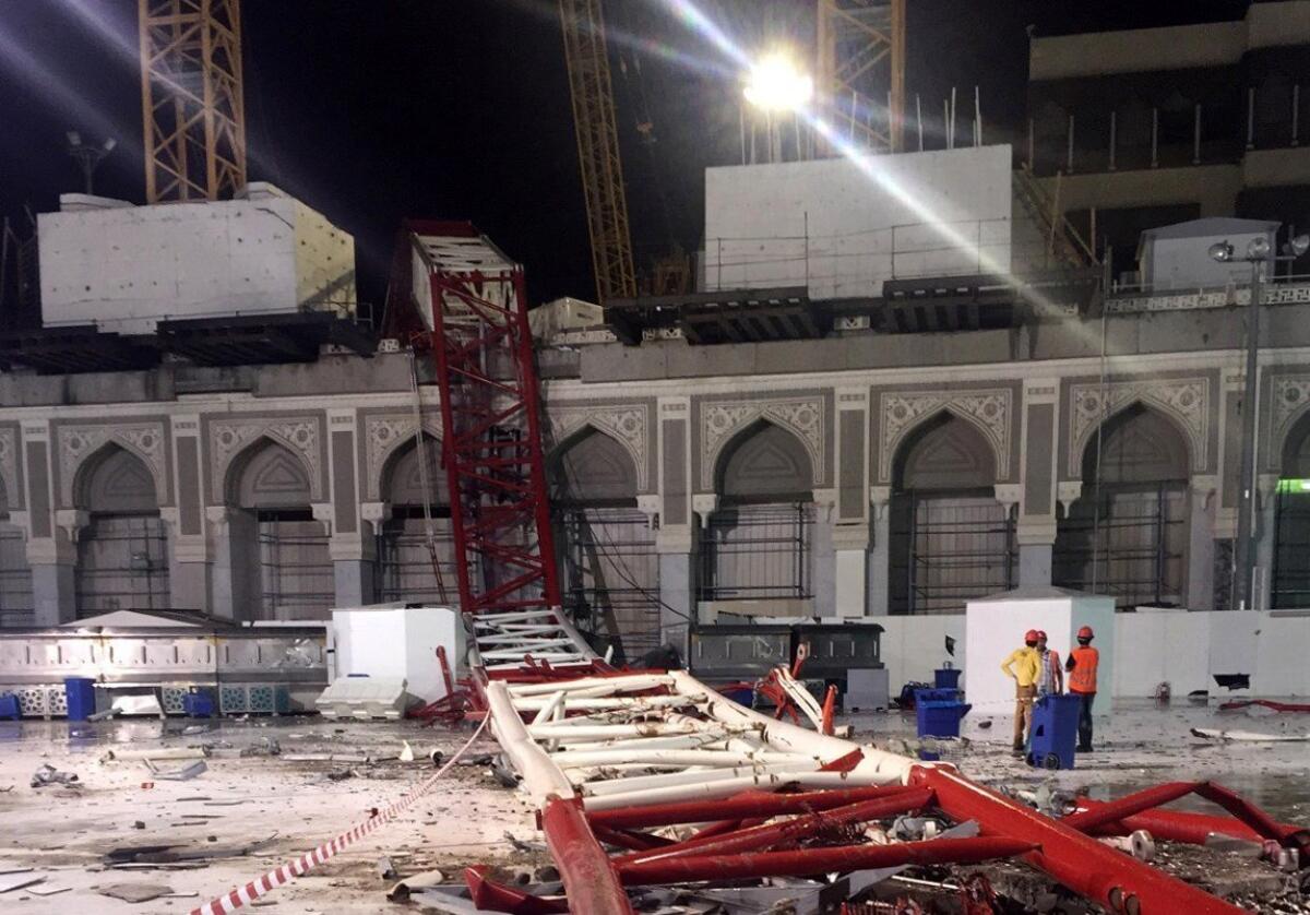 Saudi emergency teams stand next to a construction crane after it crashed into the Grand Mosque of Saudi Arabia's holy Muslim city of Mecca on September 11, 2015.