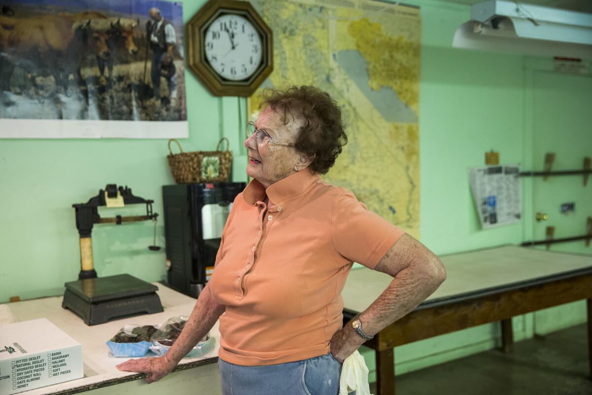 Donna Fish talks after weighing a tray of dates grown on her date and citrus farm, Brown Date Gardens in Thermal, Calif.