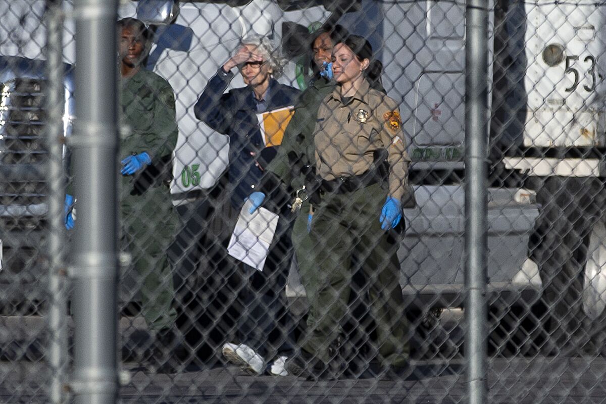 FILE - Margaret Rudin, second from left, is escorted out of Florence McClure Women's Correctional Center by prison staff on Jan. 10, 2020, in North Las Vegas. A judge on Sunday, May 15, 2022, vacated Rudin's murder conviction after she spent 20 years in prison for the 1994 killing of her millionaire husband before being paroled. Margaret Rudin was found guilty in 2001 of murder in the death of real estate mogul Ron Rudin. (Benjamin Hager/Las Vegas Review-Journal via AP, File)/Las Vegas Review-Journal via AP)
