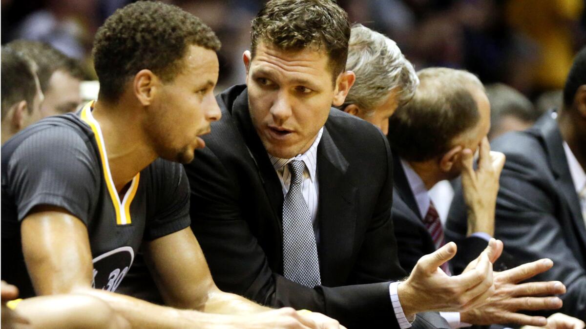 Warriors interim Coach Luke Walton talks with All-Star point guard Stephen Curry during a preaseason game.