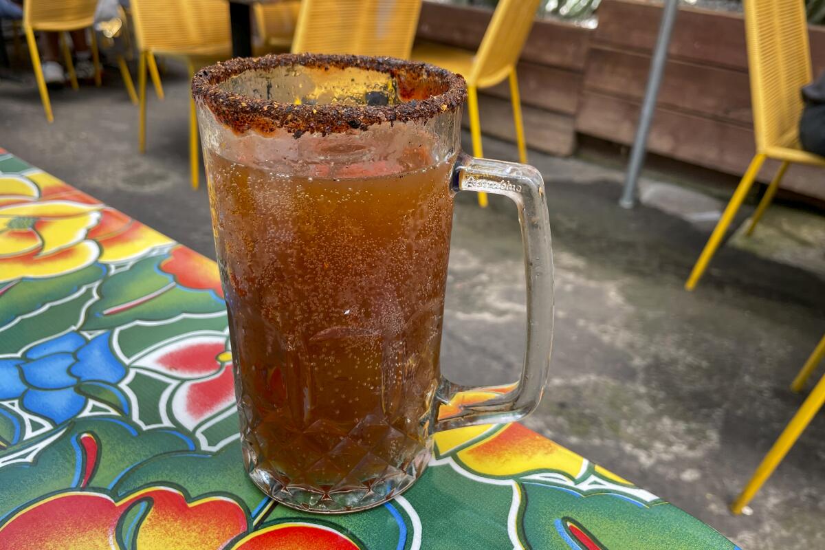 The michelada from Guelaguetza sits on a colorful tablecloth.