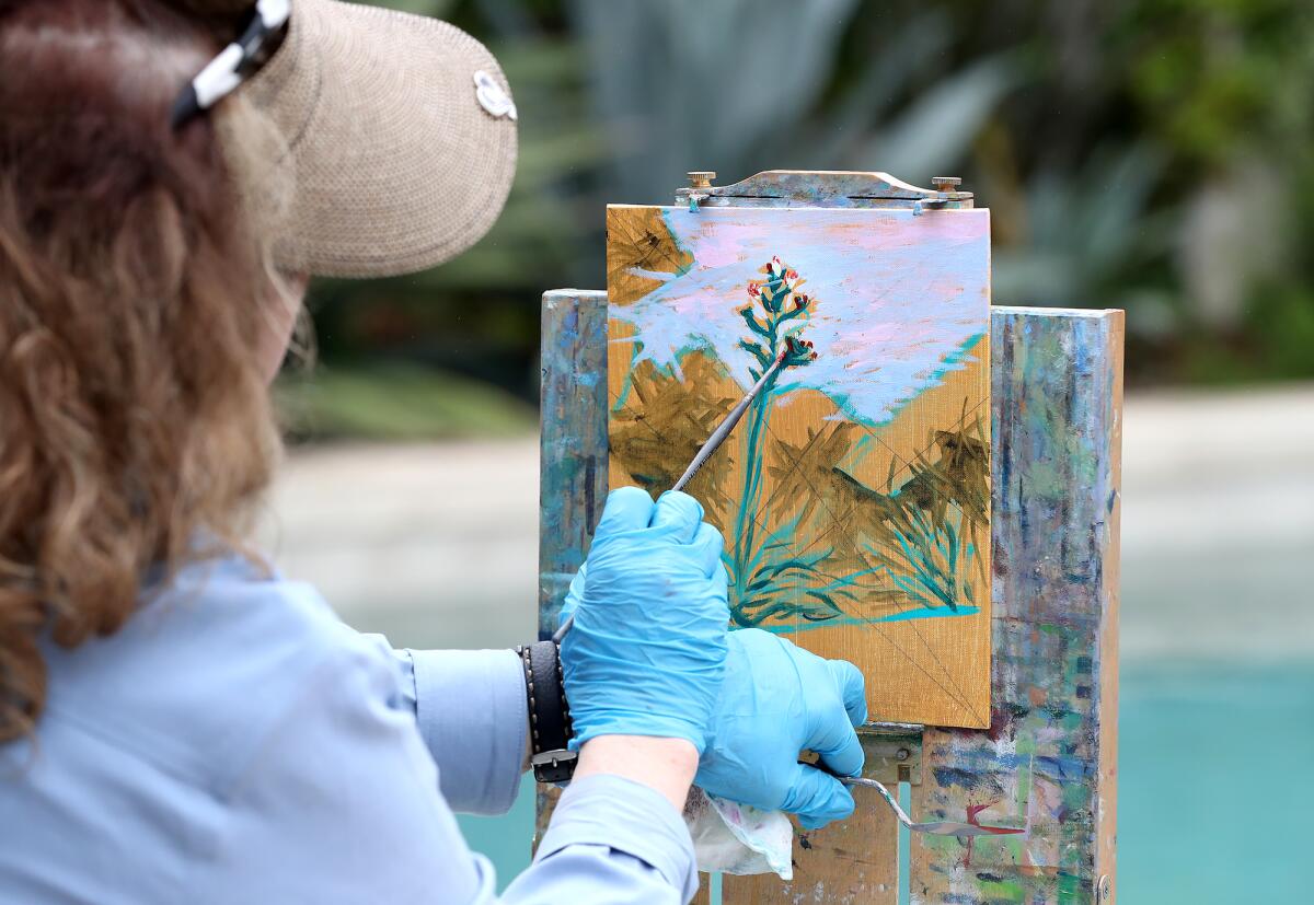 Artist Joni Emily paints a rare blooming aloe plant at the "La Hacienda" home during the Laguna Beach Garden Club tour.