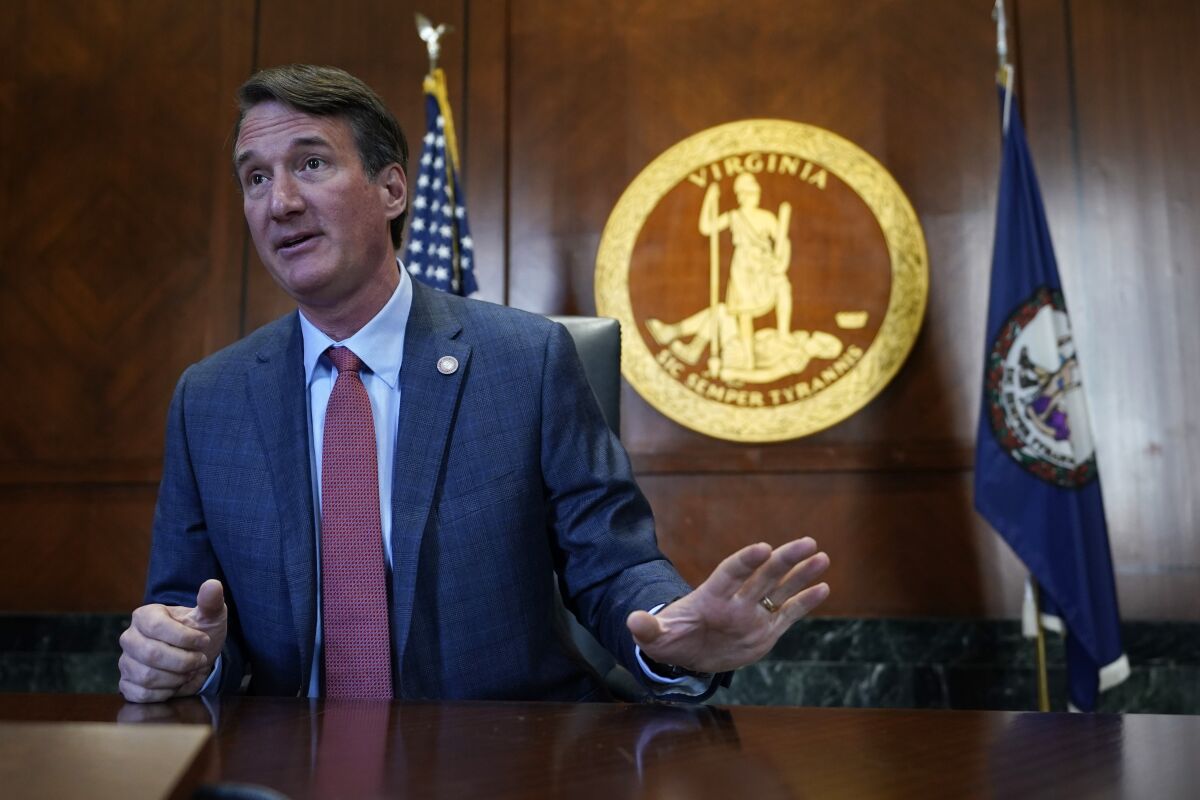 Virginia Gov. Glenn Youngkin, gestures during an interview in his office at the Capitol Tuesday Feb. 15, 2022, in Richmond, Va. Youngkin was inaugurated one month ago. (AP Photo/Steve Helber)