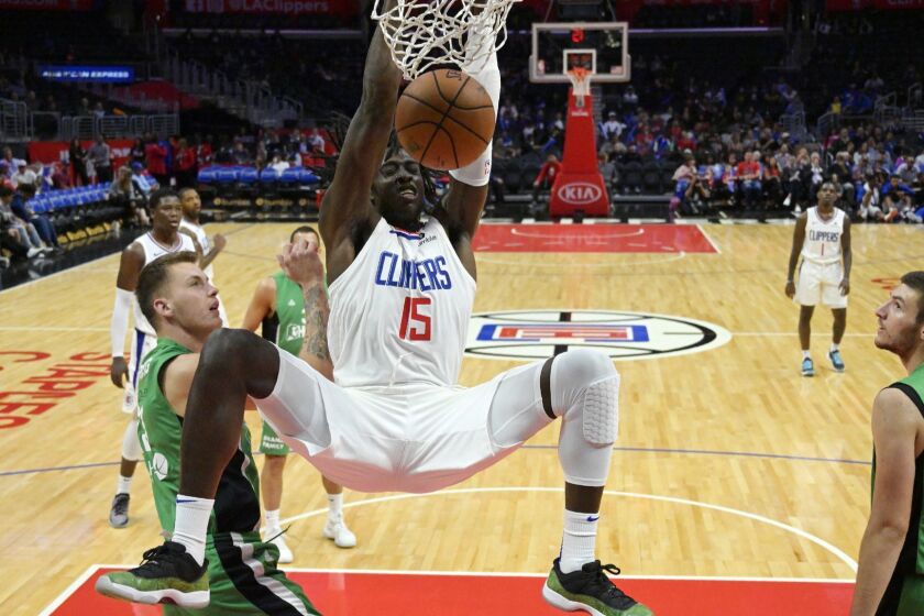 Los Angeles Clippers forward Johnathan Motley, center, dunks as Maccabi Haifa center Daniel Koperberg, left, and center Roman Sorkin defend during the second half of an NBA basketball exhibition game Thursday, Oct. 11, 2018, in Los Angeles. (AP Photo/Mark J. Terrill)