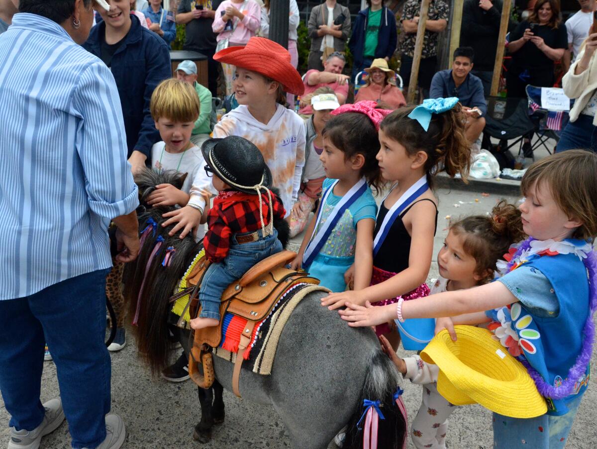 Kids gather around Mini Madness miniature horses.