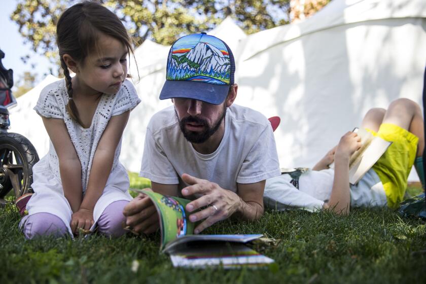 LOS ANGELES, CALIF. - APRIL 22: Aurora Carrillo-Vincent, 5, and Matthew Carrillo-Vincent, 35, read together during the annual Los Angeles Times Festival of Books at the University of Southern California on Sunday, April 22, 2018 in Los Angeles, Calif. (Kent Nishimura / Los Angeles Times)