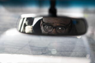 Civil rights attorney James Cook in the rear view mirror as he makes phone calls in his car in Minneapolis.