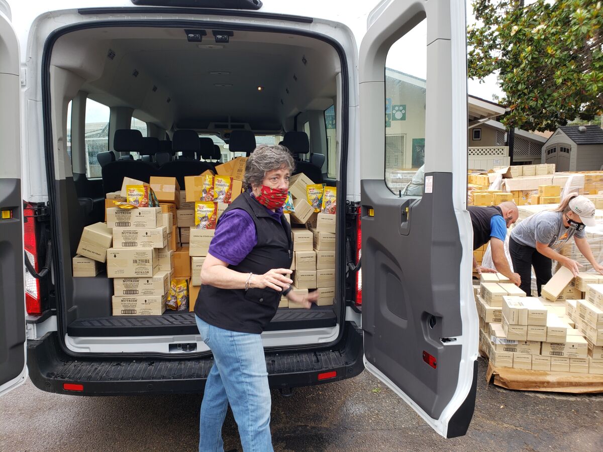 RCHS President Judi Sanzo putting the last boxes of food into a van.