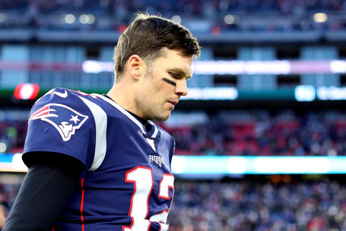 New England quarterback Tom Brady leaves the field after the Patriots' upset loss to the Miami Dolphins on Sunday in Foxborough, Mass.