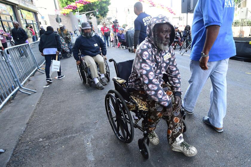 Disabled homeless people make their way to a Thanksgiving lunch outside the Los Angeles Mission on skid row.