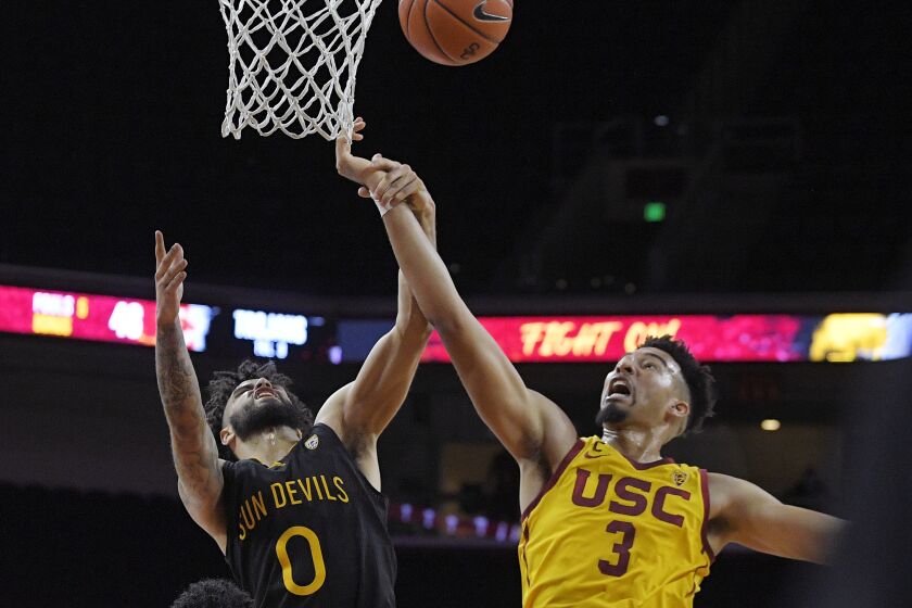 Arizona State guard Holland Woods, left, and Southern California forward Isaiah Mobley reach for a rebound during the first half of an NCAA college basketball game Wednesday, Feb. 17, 2021, in Los Angeles. (AP Photo/Mark J. Terrill)