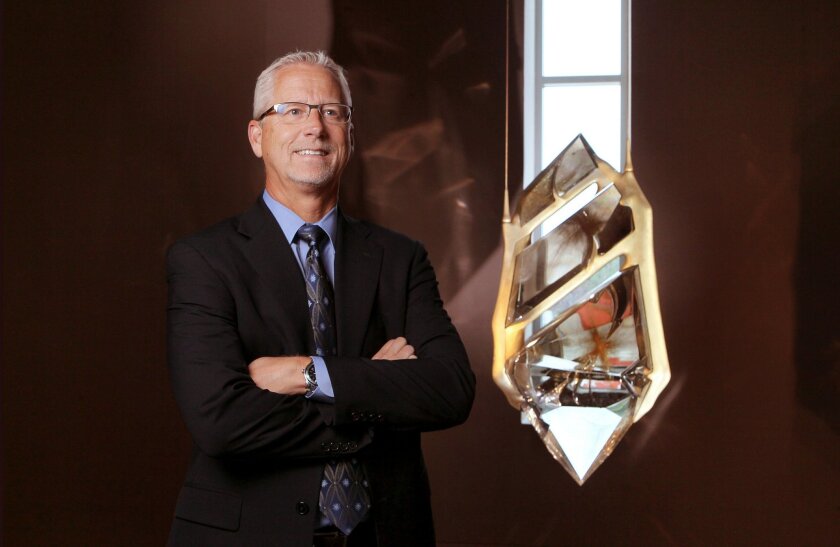Phil Yantzer, Vice President, Laboratory Services, at the Gemological Institute of America in Carlsbad, with a hanging 426 lb. rock crystal quartz sculpture named "Bahia" made of three pieces cut from a single 800 lb. rock crystal quartz from Bahia, Brazil. It's on display in the lobby of the institute.