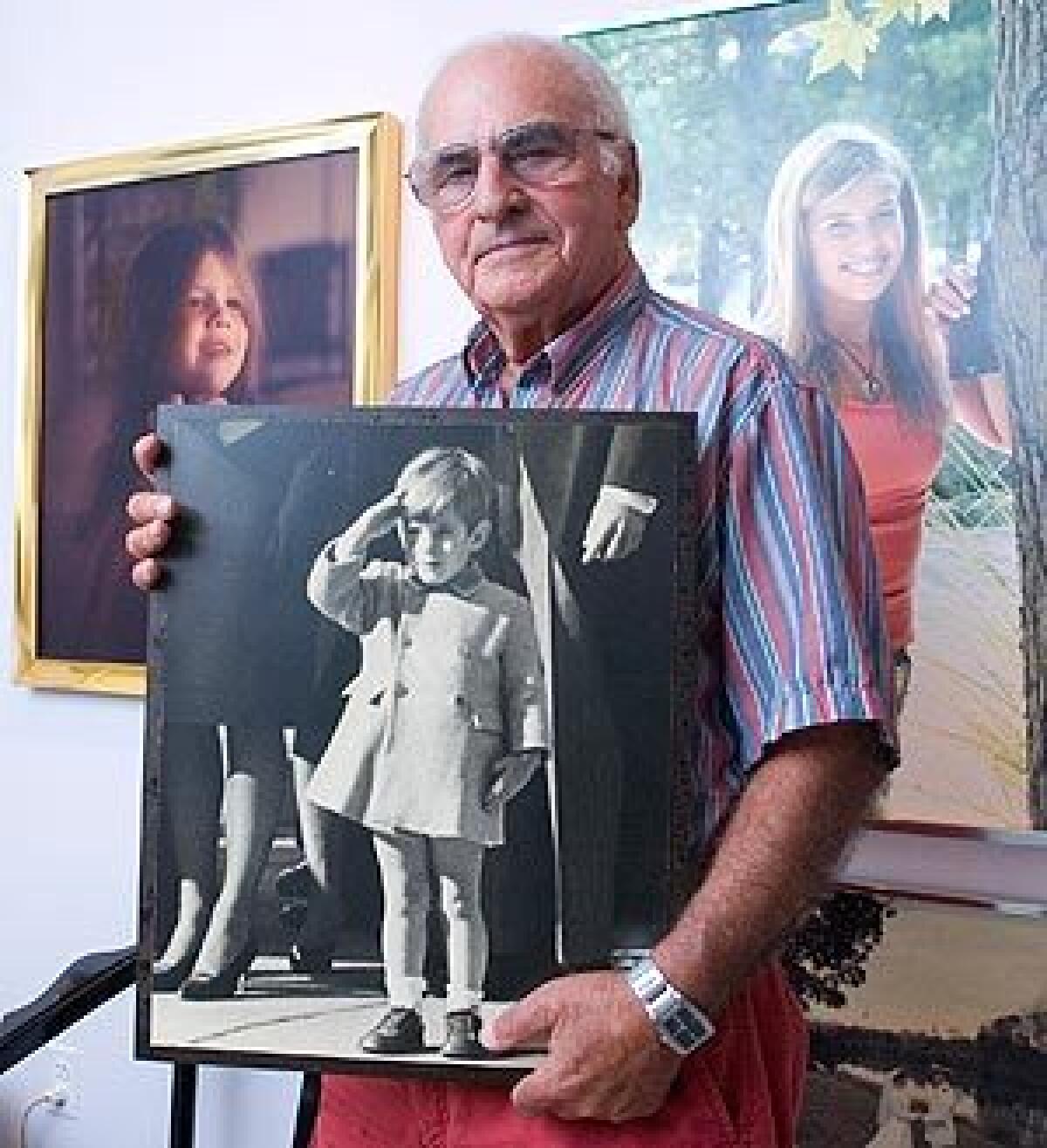 Retired United Press International photographer Stan Stearns in 2007 holds a print of his iconic photo of John F. Kennedy Jr. saluting his father's coffin in 1963.