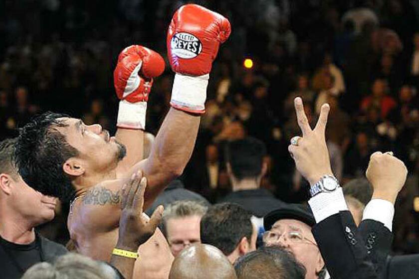Manny Pacquiao is lifted above the ring after defeating Oscar De La Hoya in eight rounds Saturday night at the MGM Grand Garden Arena in Las Vegas.