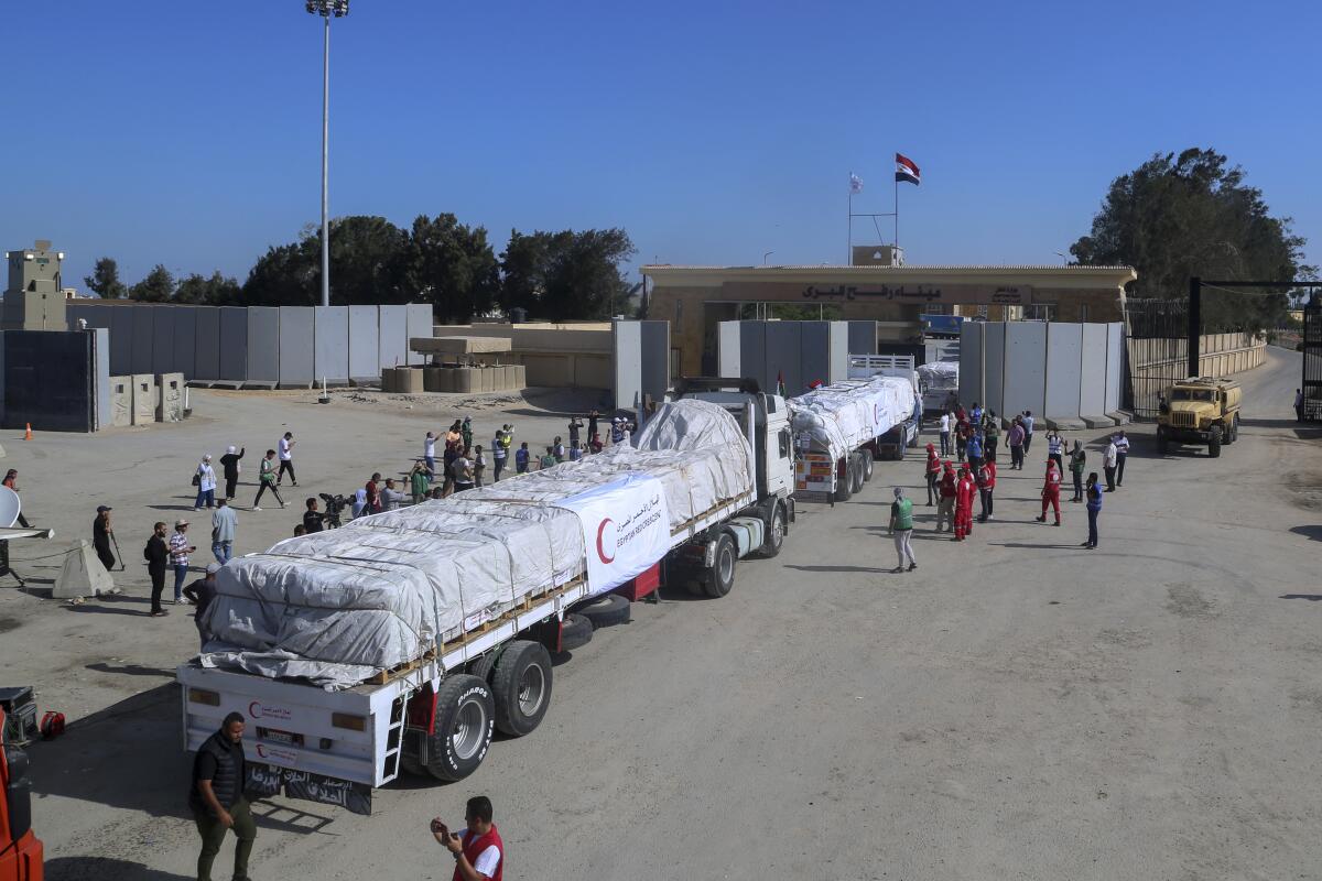 Trucks carrying humanitarian aid for the Gaza Strip wait at the border gate in Rafah, Egypt, on Oct. 21.