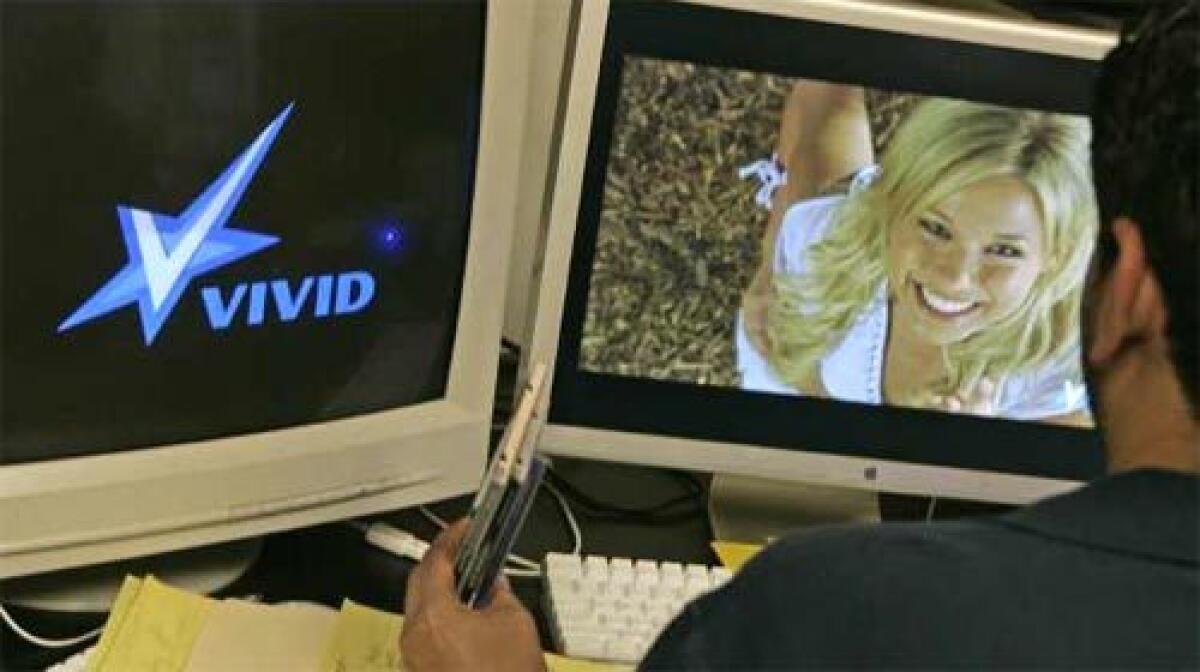 DUAL ROLE: An editor works this year at Vivid in Los Angeles. The Internet has helped porn companies boost sales, but the proliferation of unauthorized free clips online has undercut them.