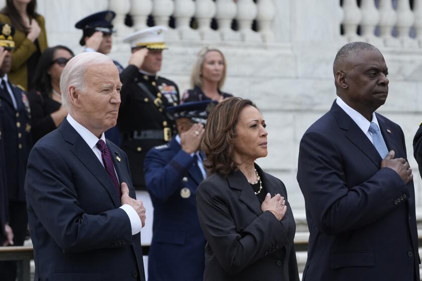 President Joe Biden, left, joined by Vice President Kamala Harris, center, and Defense Secretary Lloyd Austin, right, listen to the National Anthem during an Armed Forces Full Honors Wreath Ceremony at the Tomb of the Unknown Soldier at Arlington National Cemetery in Arlington, Va., on Memorial Day, Monday, May 27, 2024. (AP Photo/Susan Walsh)