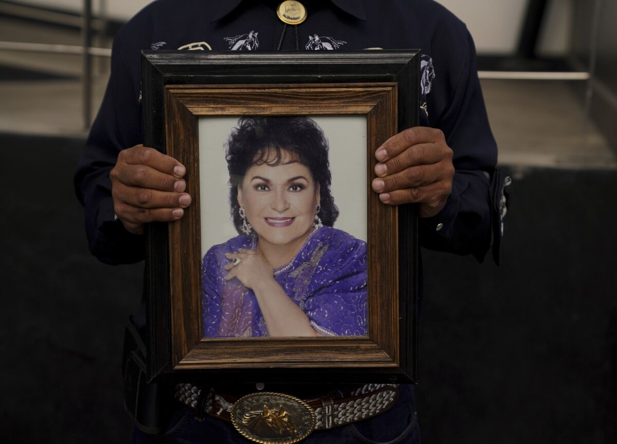 A fan holds a framed picture of Mexican actress Carmen Salinas outside a funeral home in Mexico City