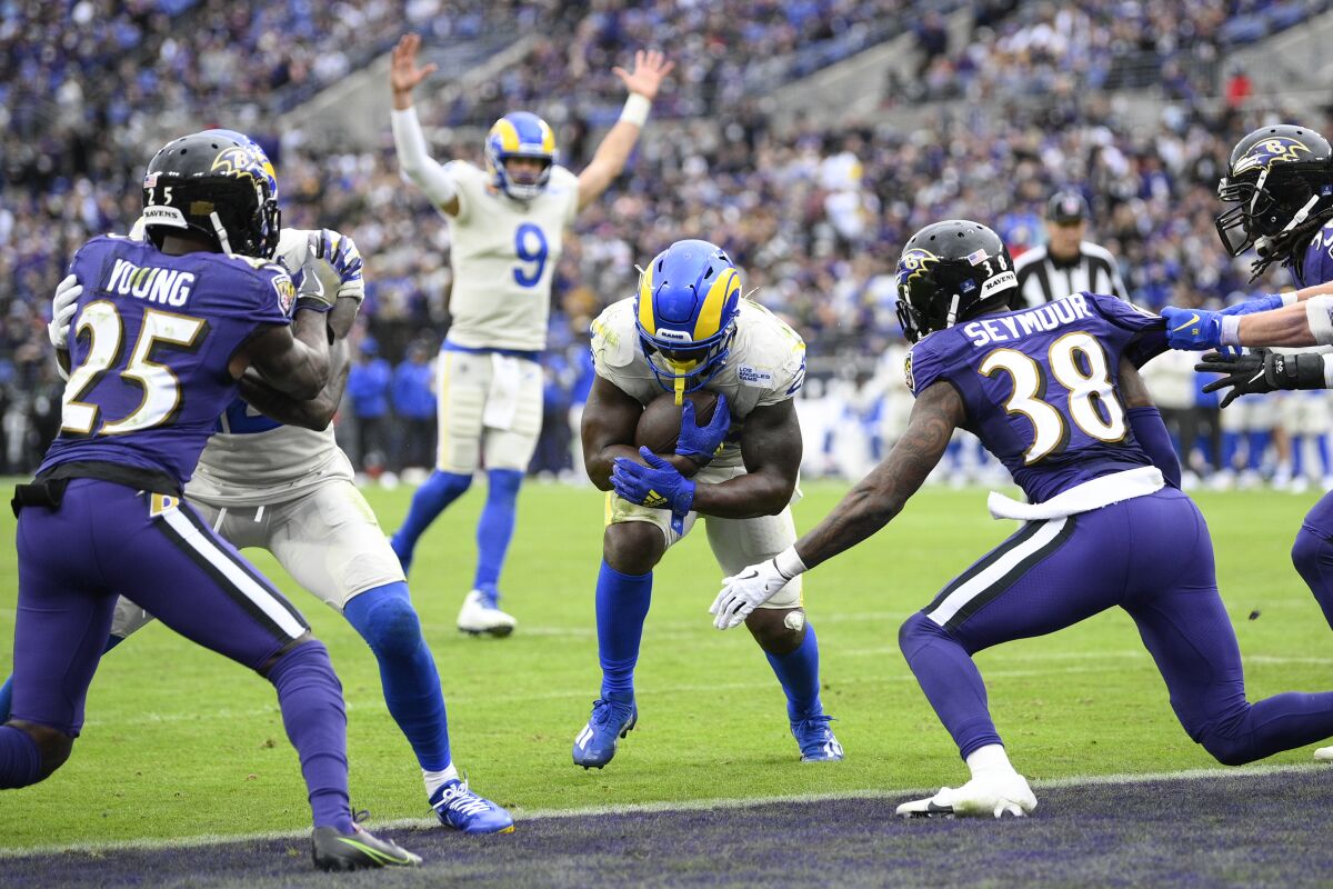 Matthew Stafford (9) signals touchdown as Rams teammate Sony Michel crosses the goal line against the Ravens.