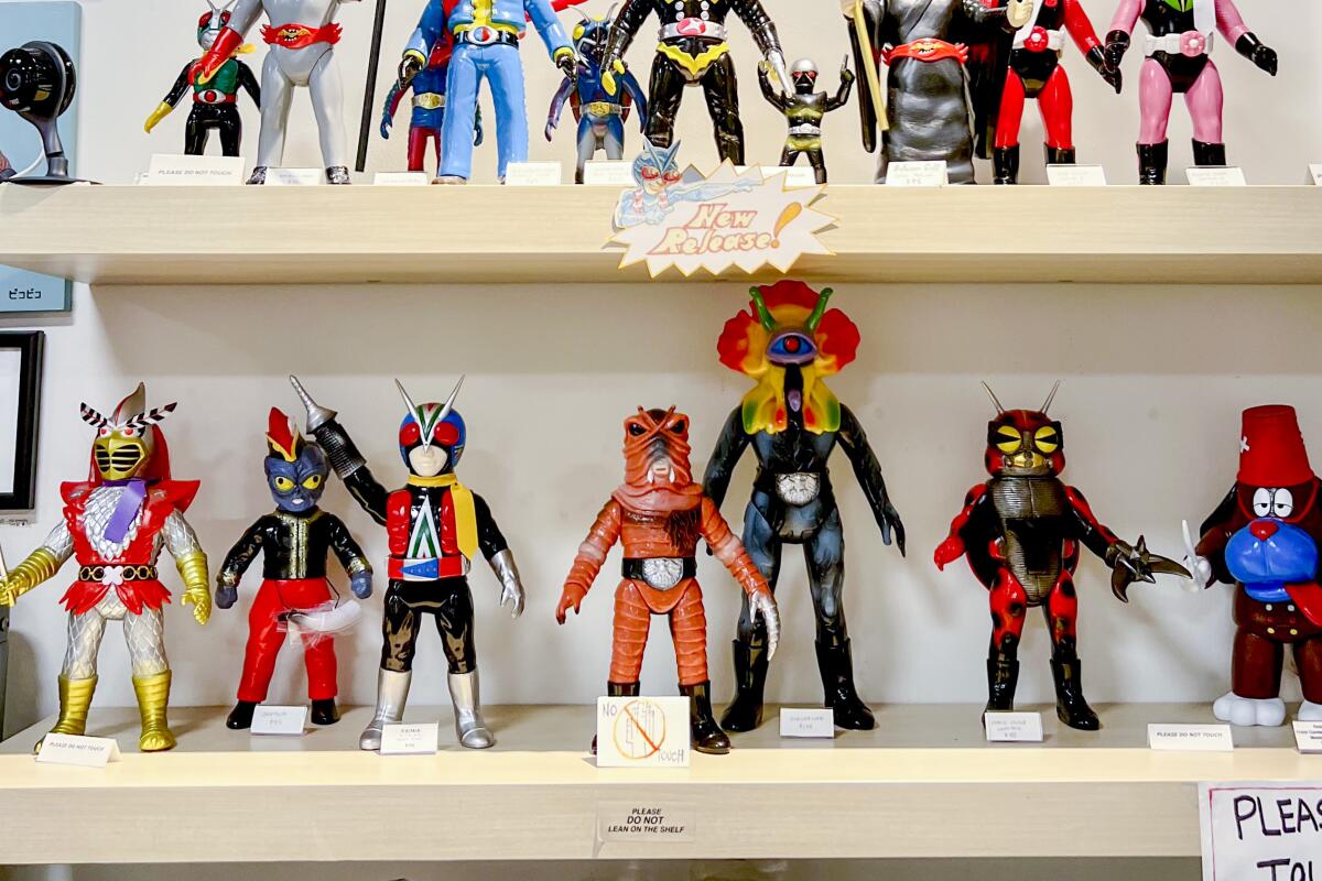 Shelves of action figures under framed animation art