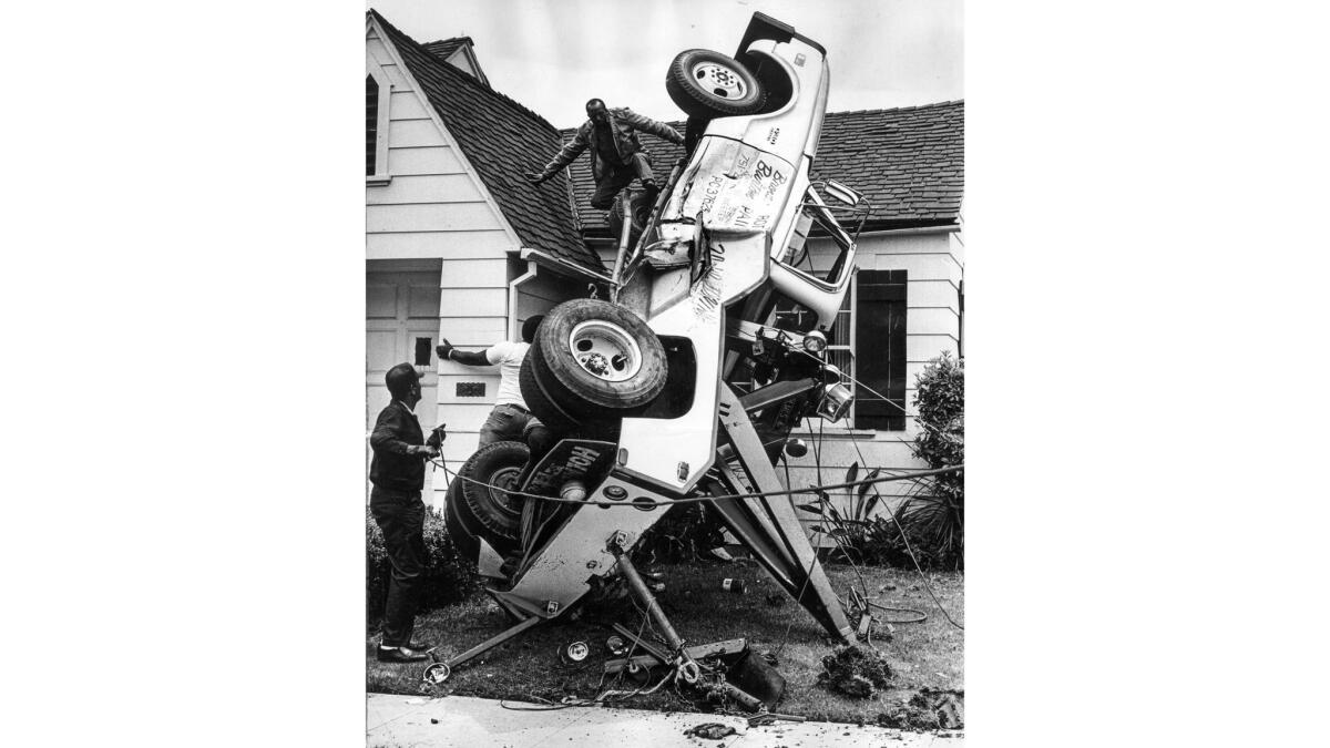 June 2, 1971: An overturned tow truck rests against a house in the 1700 block of West 78th Street in Los Angeles.