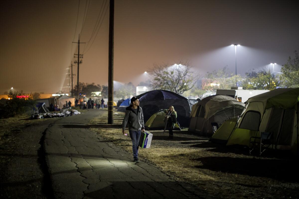 Evacuees from the Camp fire have congregated in tents in a vacant lot next to a Walmart in Chico.
