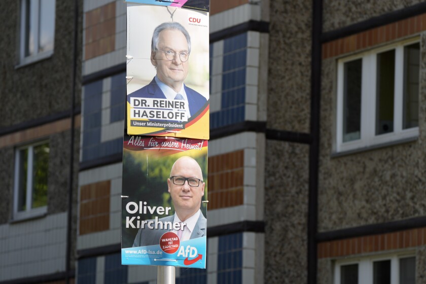 Election campaign posters from Merkel's Christian Democratic Union, CDU, with top candidate and state governor Reiner Haseloff, top, and from the far-right Alternative for Germany, AFD, party with top candidate, Oliver Kirchner, displayed in front of a residents building at federal state Saxony-Anhalt's capital Magdeburg, Germany, Wednesday, June 2, 2021.The state vote on Sunday, June 6, 2021 is German politicians' last major test at the ballot box before the national election in September that will determine who succeeds Chancellor Angela Merkel. (AP Photo/Markus Schreiber)