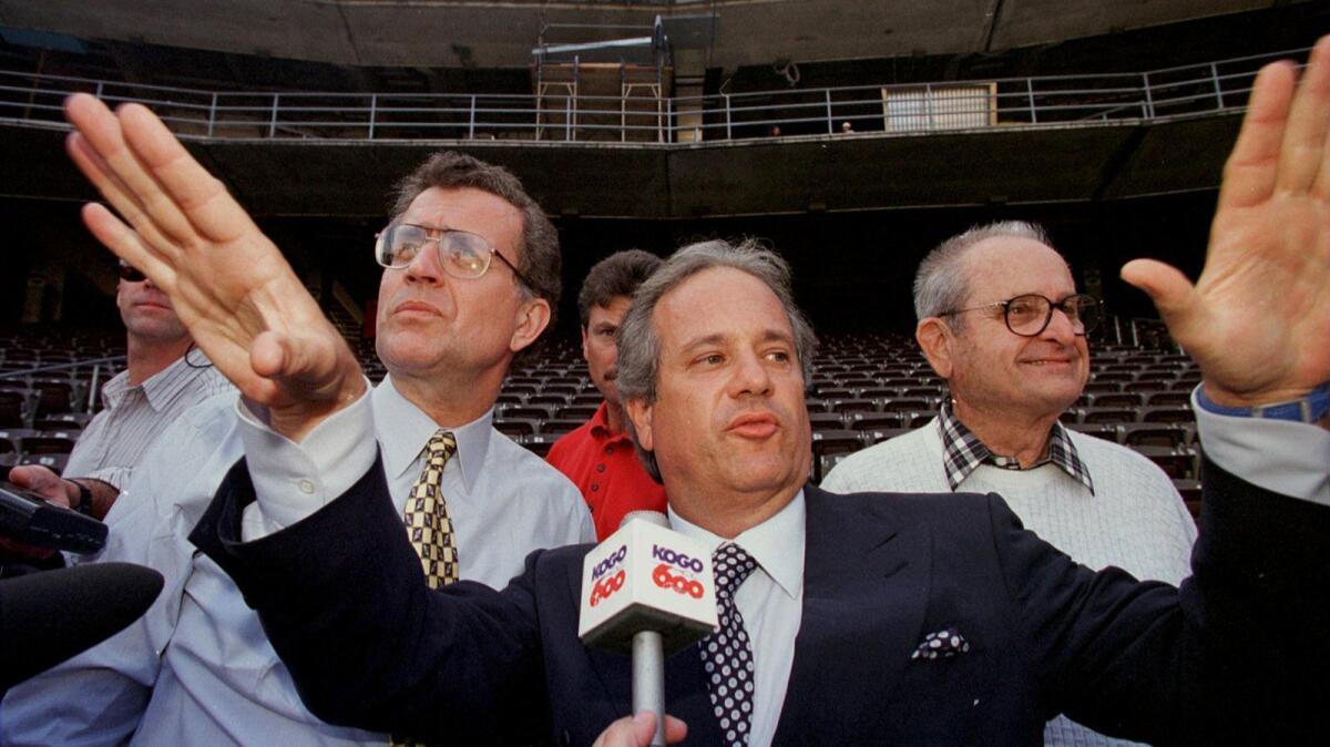 Chargers chairman Dean Spanos (center) talks about stadium expansion progress at what was then Jack Murphy Stadium in San Diego in 1997. Listening are then-NFL Commissioner Paul Tagliabue, left, and Chargers owner Alex Spanos.