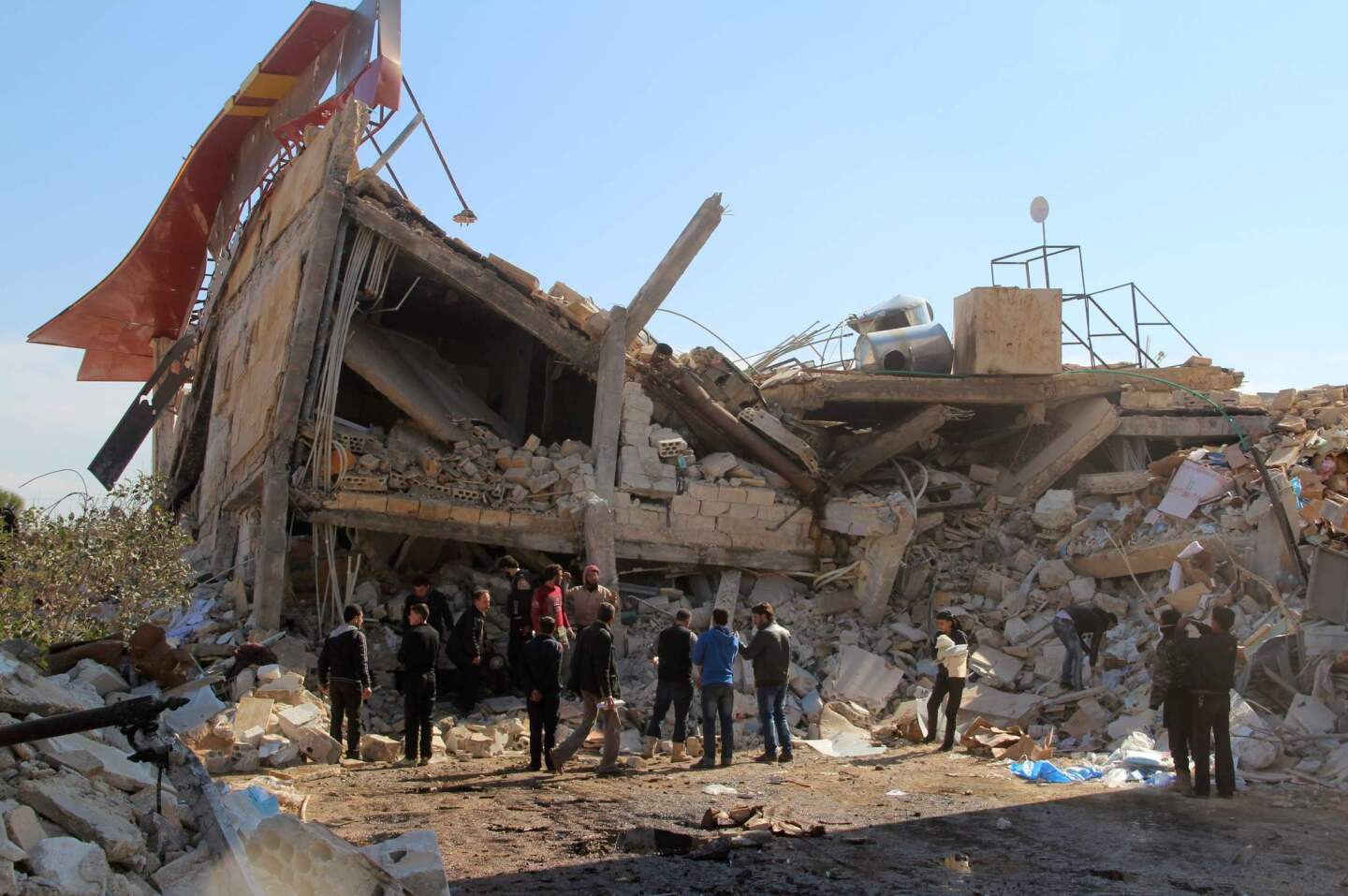 People gather around the rubble of a hospital supported by Doctors Without Borders near Maaret al-Numan, in Syria's northern province of Idlib, on Feb. 15, 2016, after the building was hit by suspected Russian airstrikes.