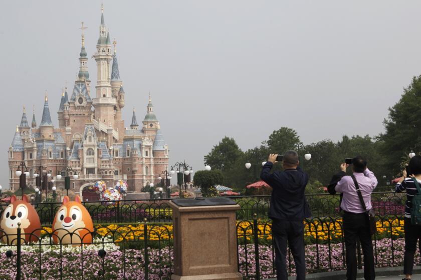 Visitors take photos of Shanghai Disneyland, which reopened on Monday.