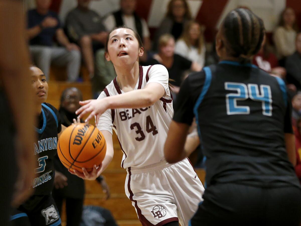 Laguna Beach's Kate Cheng (34) finishes a drive for a layup against Canyon Springs on Wednesday.