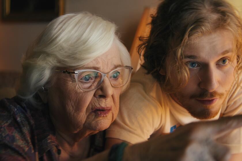 A grandmother and her grandson look at a computer screen.